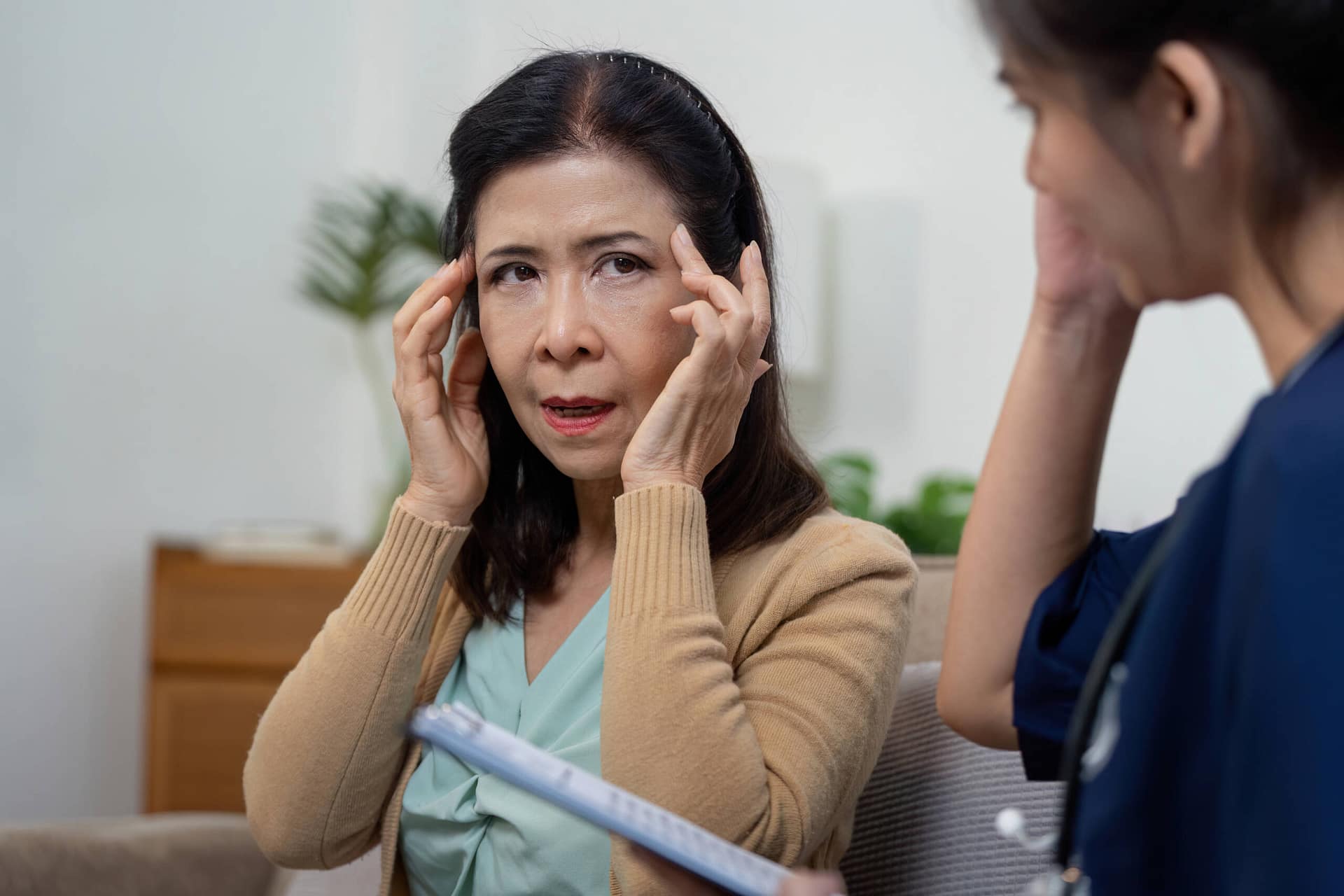 Elderly patient consults caregiver nurse and doctor for health advice clinic healthcare interaction indoor setting close-up view wellness An elderly woman seeks advice from her caregiver and a healthcare team for her health concerns in a clinic setting.