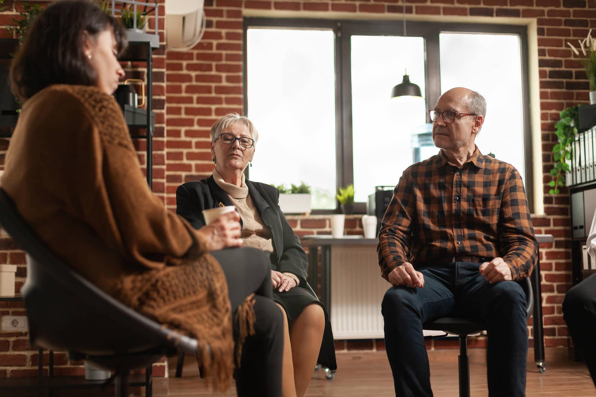 People talking to psychologist at aa group therapy session People talking to psychologist at aa group therapy session, sharing addiction problems. Multi ethnic patients having discussion about alcohol issues with specialist at support meeting program.